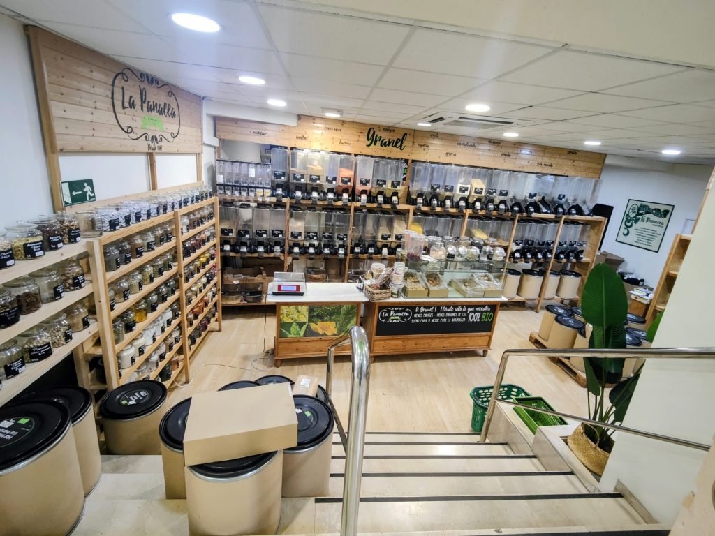 Interior de la tienda La Panacea en la calle Veracruz de Jerez, con las estanterías de madera y la zona de granel al fondo